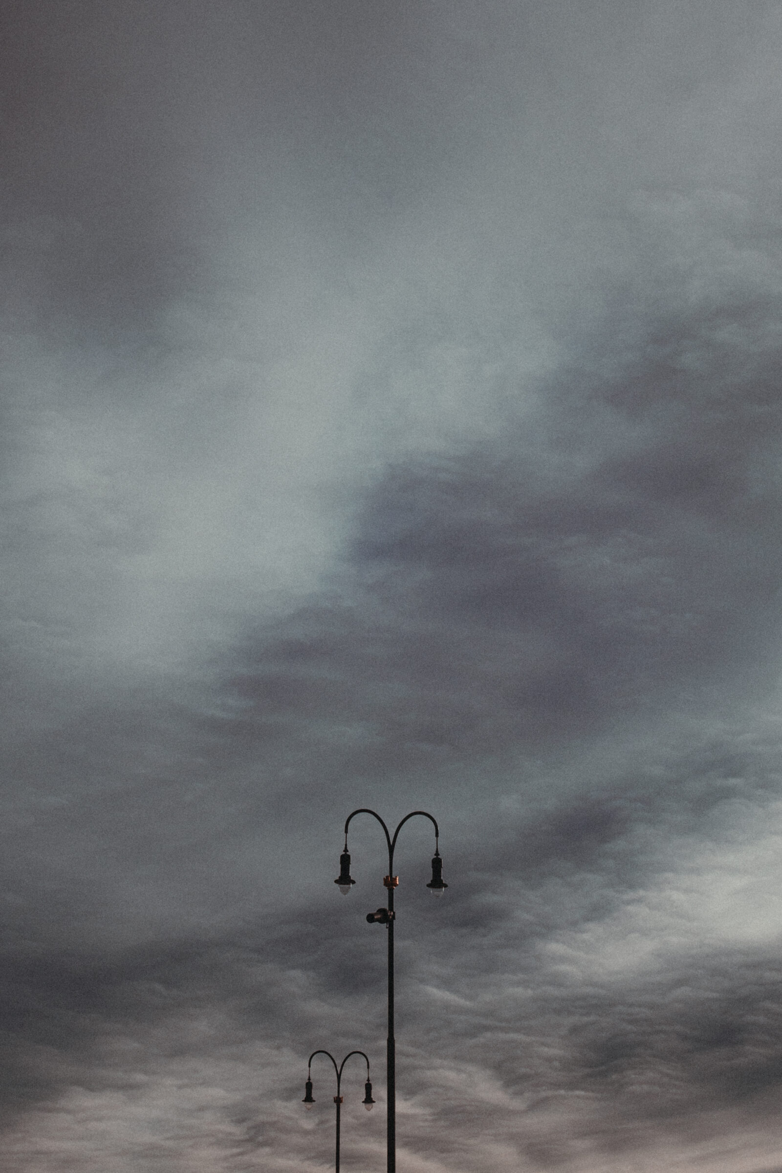 street lamps at rådhusplassen in oslo under a heavy sky